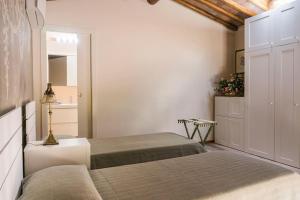 1 dormitorio con 2 camas y espejo en FAETOLE typical Tuscan country house near FLORENCE, en Capannuccia