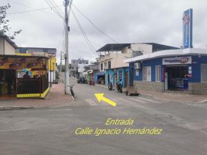 una calle vacía en un pueblo con una flecha amarilla en Mark’s home, en Puerto Ayora