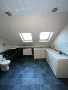 uma casa de banho com 2 janelas, um lavatório e um WC. em 19A Stourwood Avenue em Southbourne