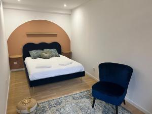 1 dormitorio con 1 cama y 1 silla azul en Le Rêve Bleu Appartement Hyper-centre, en Carcassonne