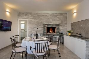 a dining room with a table and a fireplace at Villa Lilin San in Donji Humac
