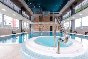 a swimming pool with a hot tub in a building at Apartament Faleza in Rewal
