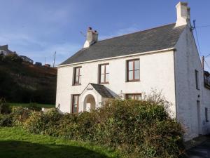 a white house with a gray roof at Gladstone in Pwllheli