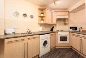 a kitchen with a sink and a dishwasher at Isla Retreat - Donnini Apartments in Ayr