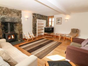 a living room with a couch and a fireplace at Gladstone in Pwllheli