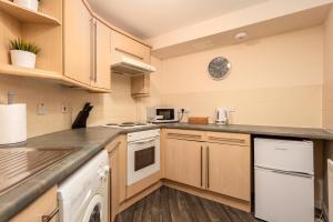 a large kitchen with wooden cabinets and appliances at Isla Retreat - Donnini Apartments in Ayr