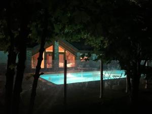 uma piscina em frente a uma casa à noite em Chalet savoyard indépendant em La Toussuire