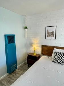 - une chambre avec un lit et une lampe sur une table dans l'établissement The Postcard Motel, à Seligman