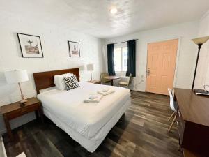 1 dormitorio con cama, mesa y puerta en The Postcard Motel, en Seligman