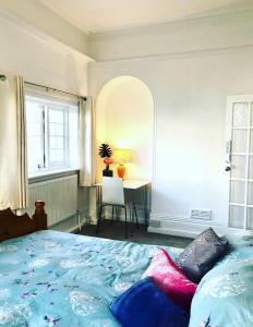 a bedroom with a bed with colorful pillows on it at Seaside in Worthing