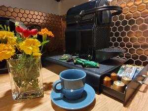 una cafetera con una taza y un jarrón de flores en Ogrodowa 4, en Ustrzyki Dolne