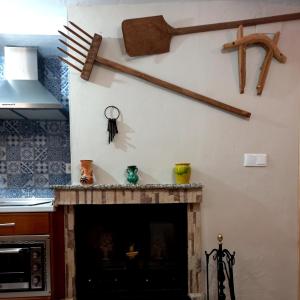 a room with a fireplace with a broom on the wall at Casa Angel in Cazorla