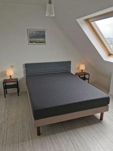 Bett in einem Zimmer mit 2 Tischen und 2 Lampen in der Unterkunft Maison de vacances proche des plages et du GR34 in Sibiril