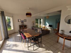 uma sala de jantar e sala de estar com mesa e cadeiras em Maison de vacances proche des plages et du GR34 em Sibiril