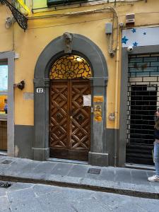 een grote houten deur aan de zijkant van een gebouw bij La Piccola Maison in Florence