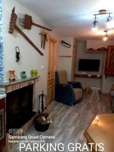 a living room with a fireplace and a tv at Casa Angel in Cazorla