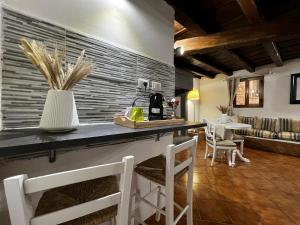 a kitchen and living room with a counter and chairs at La Piccola Maison in Florence