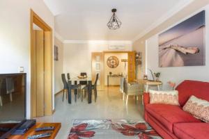 - un salon avec un canapé rouge et une salle à manger dans l'établissement Apartamentos Solmar, à Albufeira