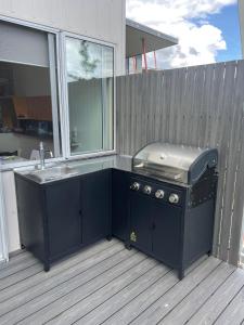 a grill and a sink on a deck at luxury Scandinavian townhouse in Mount Beauty