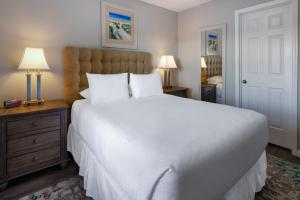 a bedroom with a large white bed and two lamps at Sea Mystique Resort in Myrtle Beach