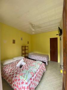 2 łóżka w pokoju z żółtymi ścianami w obiekcie Pousada Vale do Luar w mieście Sana