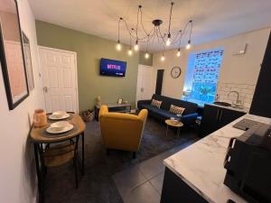 a kitchen and living room with a couch and a table at Modern & retro two bedroom apartment in Barnsley in Barnsley
