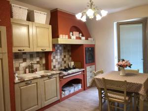 a kitchen with a table and a kitchen with a fireplace at Villa Elisa in Saluzzo