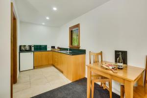uma cozinha com uma mesa de madeira e uma mesa de madeira e uma mesa de madeira em Harrogate Gardens Motel em Hanmer Springs