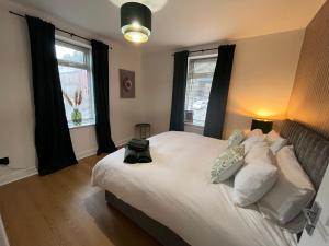 1 dormitorio con 1 cama blanca grande con almohadas en Modern & retro two bedroom apartment in Barnsley en Barnsley