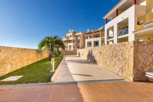 une passerelle devant un bâtiment avec un mur dans l'établissement Apartamentos Solmar, à Albufeira