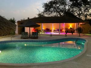 a swimming pool in front of a house at night at Villa Kounzo in Ndangane