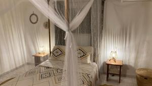 a bedroom with a canopy bed with two night stands at Villa Kounzo in Ndangane