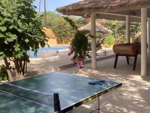 a ping pong table in front of a pool at Villa Kounzo in Ndangane