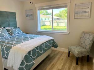 a bedroom with a bed and a chair and a window at Guest Suites 1996 #4- Relaxing 1 bedroom 1 bath Suite in Idaho Falls