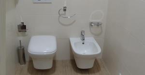 un bagno bianco con un water e un lavandino di Residence SANTABBONDIO a Como Altre 37 foto
