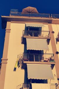 een hoog gebouw met balkons, tafels en een paraplu bij G&G Holidays in Santa Maria di Castellabate