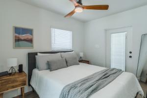 a bedroom with a white bed with a ceiling fan at Luxury Tiny Home 2 Miles from Downtown Orlando in Orlando