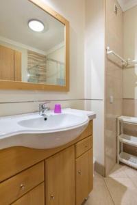 La salle de bains est pourvue d'un lavabo blanc et d'un miroir. dans l'établissement Apartamentos Solmar, à Albufeira