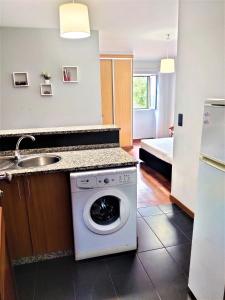 a kitchen with a washing machine and a sink at Funchal Old Town Studios - Historic Atlantic View in Funchal