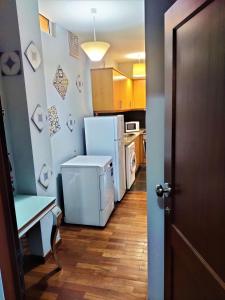 cocina con nevera, mesa y puerta en Funchal Old Town Studios - Historic Atlantic View, en Funchal