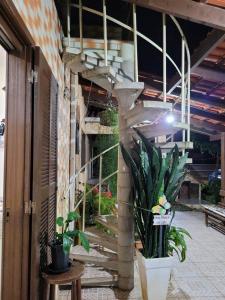 a building with stairs and potted plants on a patio at Quarto Suíte Itapoá - SC in Itapoa