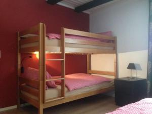 a bunk bed in a bedroom with a red wall at Alp Appartments in Tösens
