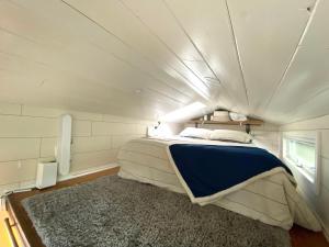een slaapkamer met een bed in een kleine kamer bij Teal Tiny Home Creek Views in San Luis Obispo