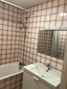 La salle de bains est pourvue d'un lavabo, d'une baignoire et d'un miroir. dans l'établissement Superbe Appartement en plein centre ville., à La Roche-sur-Yon