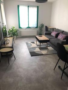 a living room with a couch and a table at Superbe Appartement en plein centre ville. in La Roche-sur-Yon