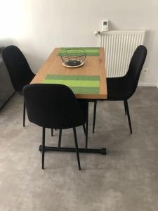 a wooden table with two chairs and a plate on it at Superbe Appartement en plein centre ville. in La Roche-sur-Yon