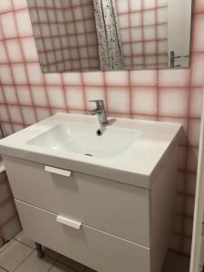 La salle de bains est pourvue d'un lavabo blanc et d'un miroir. dans l'établissement Superbe Appartement en plein centre ville., à La Roche-sur-Yon