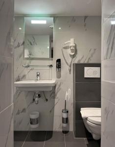 een witte badkamer met een wastafel en een toilet bij Facade Hotel Amsterdam in Amsterdam