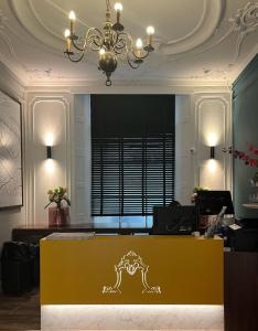 a room with a yellow desk and a chandelier at Facade Hotel Amsterdam in Amsterdam