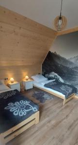 a bedroom with two beds in a wooden cabin at Willa Hajnówka in Zakopane